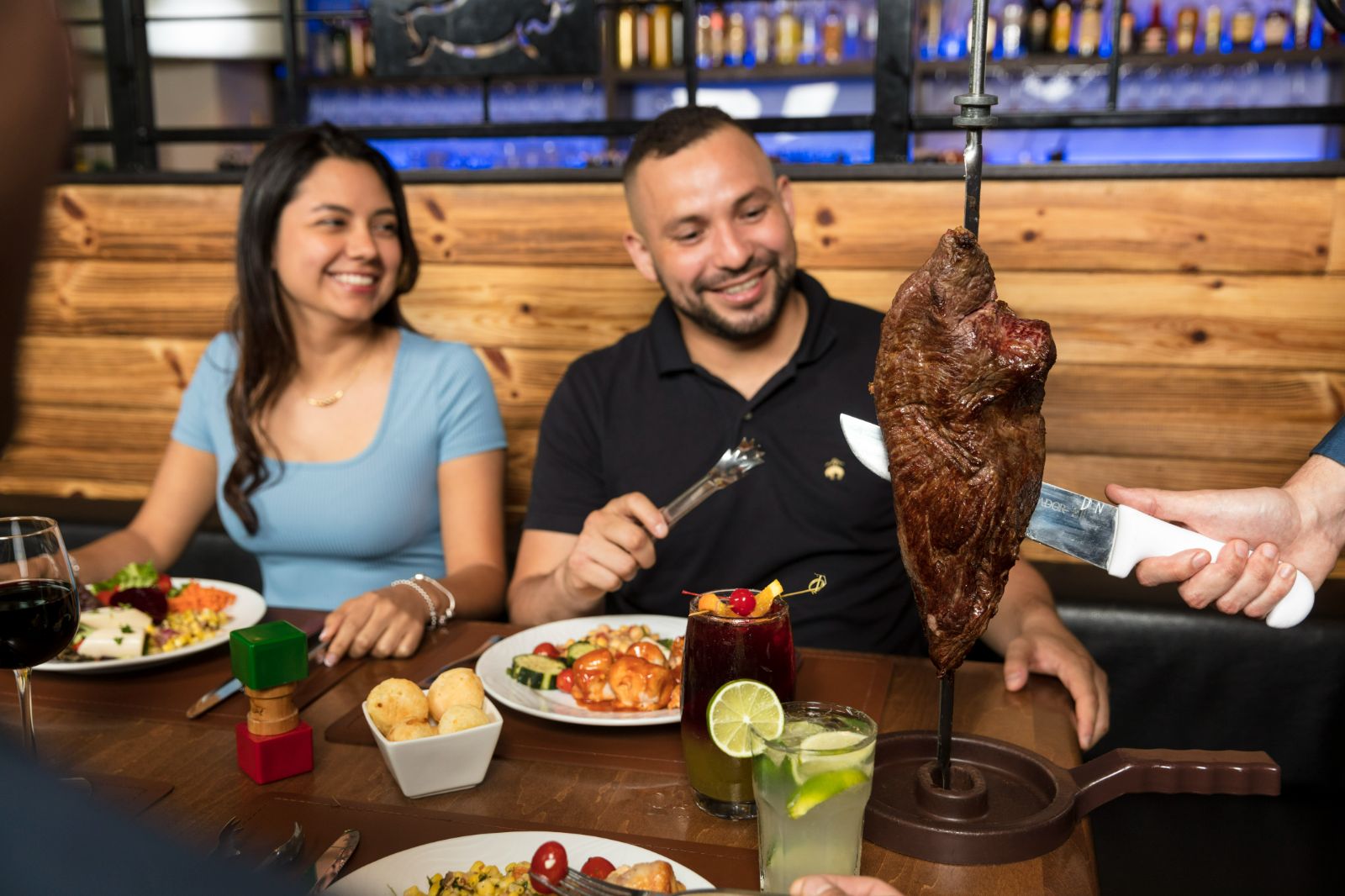 Rodizio Grill North Scottsdale a man and woman sitting at a table with food
